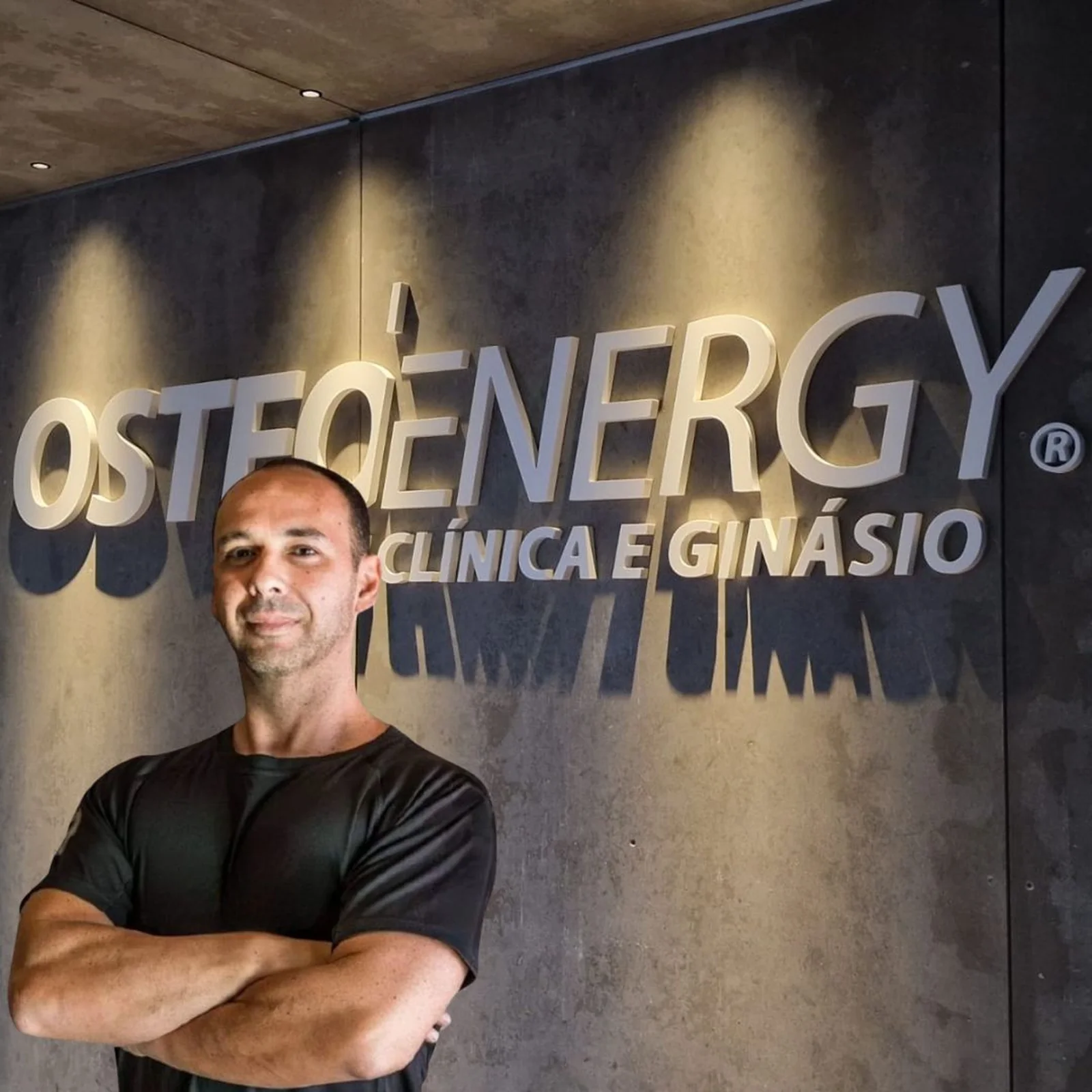 Dr. Fábio Bazílio, diretor clínico e cofundador da Osteoenergy, junto ao letreiro da clínica